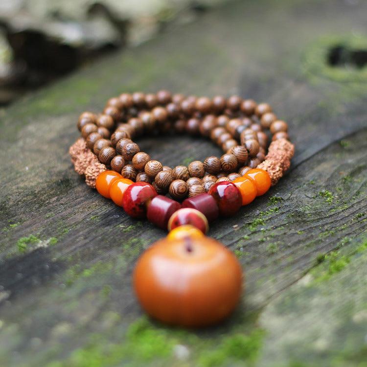 Natural wood and seed bead mala necklace with earthy tones, perfect for meditation and grounding, featuring amber, Rudraksha, and sandalwood beads.