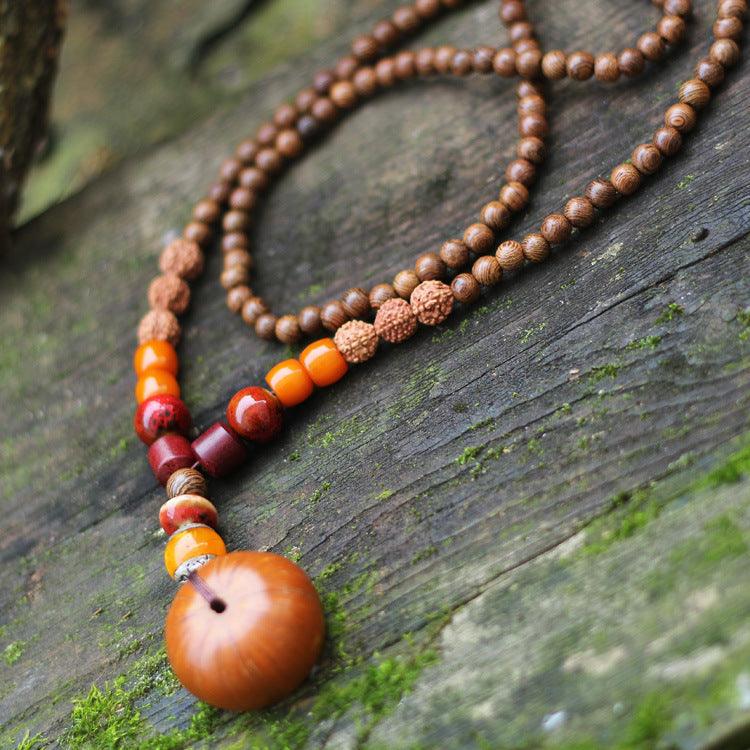 Natural wood and seed bead mala necklace with earthy tones, perfect for meditation and grounding, featuring amber, Rudraksha, and sandalwood beads.