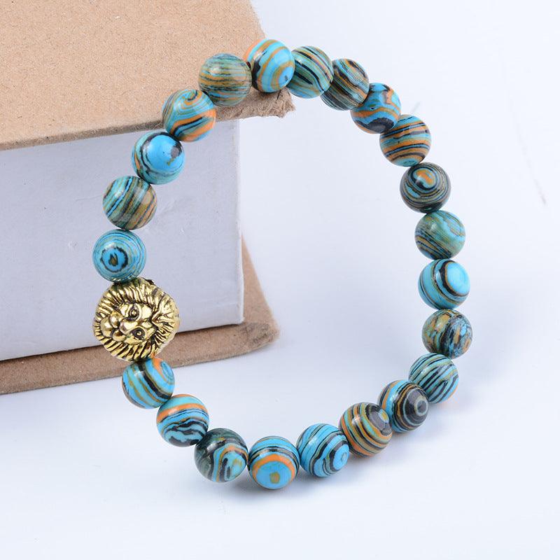 Turquoise and orange swirled gemstone bracelet with gold lion charm for strength and courage.