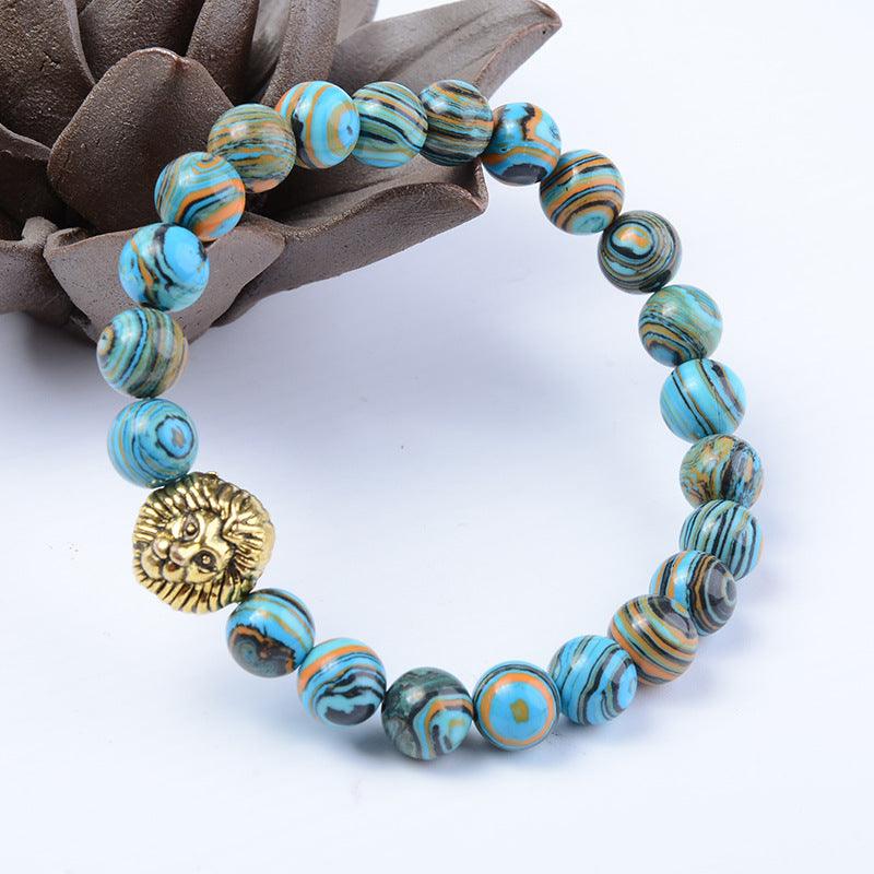 Turquoise and orange swirled gemstone bracelet with gold lion charm for strength and courage.