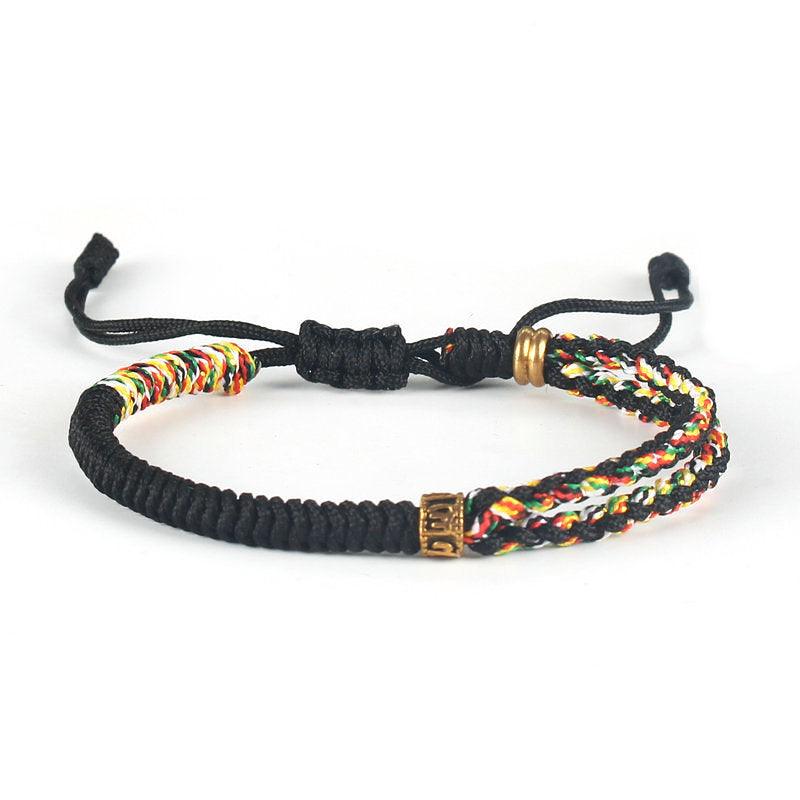 Full view of Tibetan-style black woven bracelet with multicolored cord and brass accents, symbolizing strength, cultural depth, and vibrancy.
