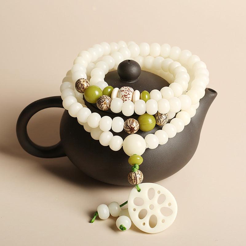 A complete view of the white jade Bodhi Mala adorned with a lotus root pendant, symbolizing purity, spiritual growth, and the path to enlightenment.
