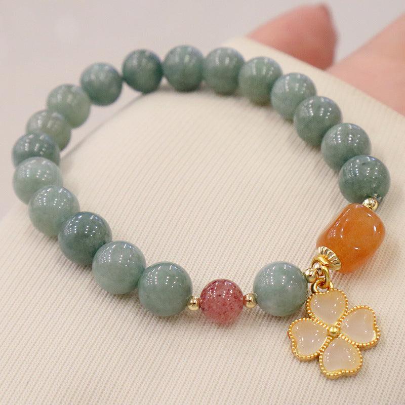 A jade bracelet with a four-leaf clover charm, reflecting its roots in Chinese culture where it symbolizes prosperity, harmony, and good fortune.