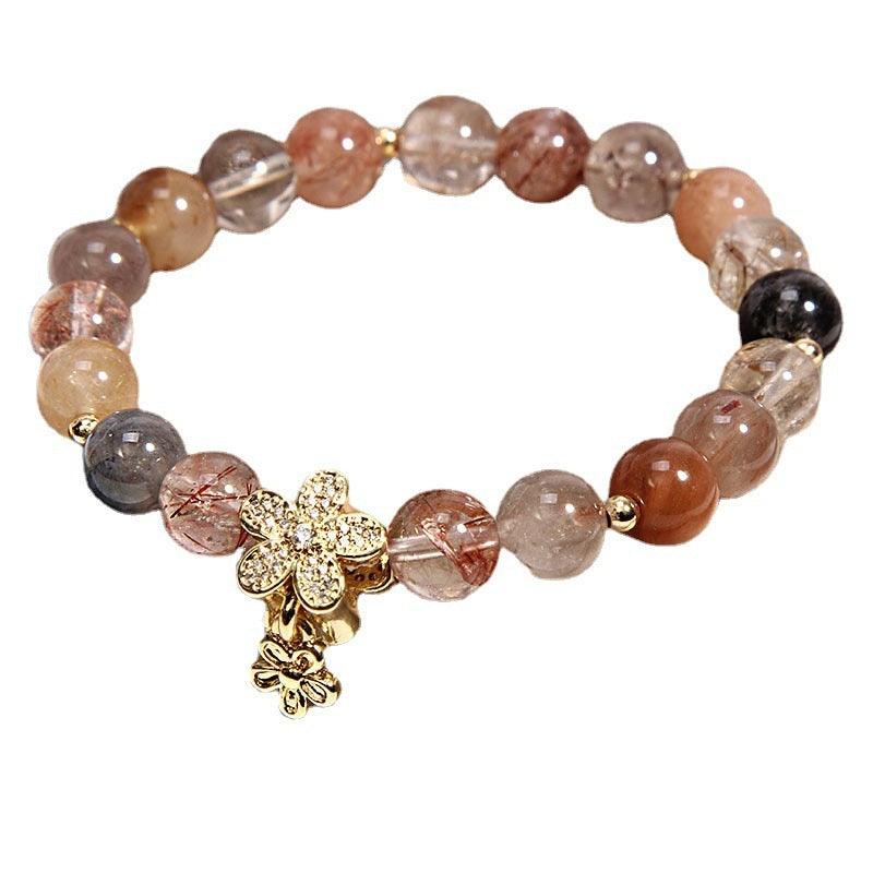 A stylish rutilated quartz bracelet with golden floral charm, blending natural tones and refined elegance, ideal for daily wear and special occasions alike.