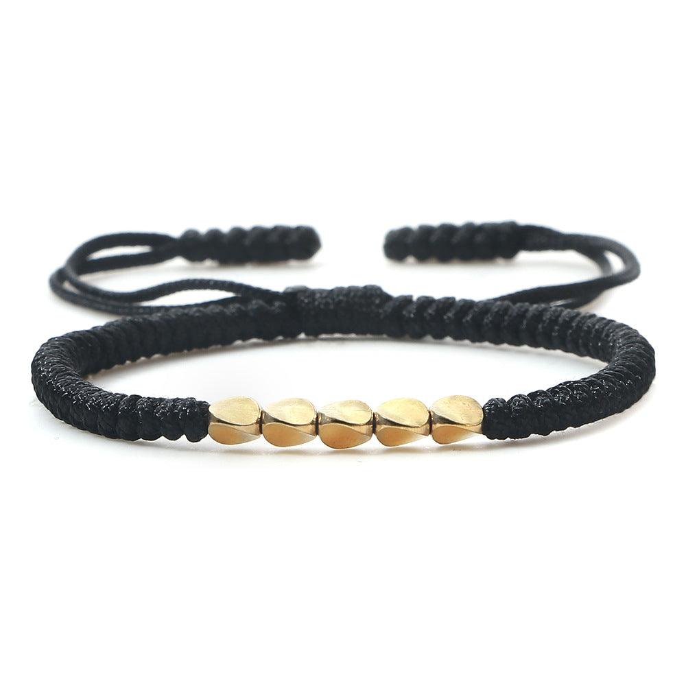 Black cord bracelet with sleek gold beads, a versatile accessory that blends tradition with modern style.