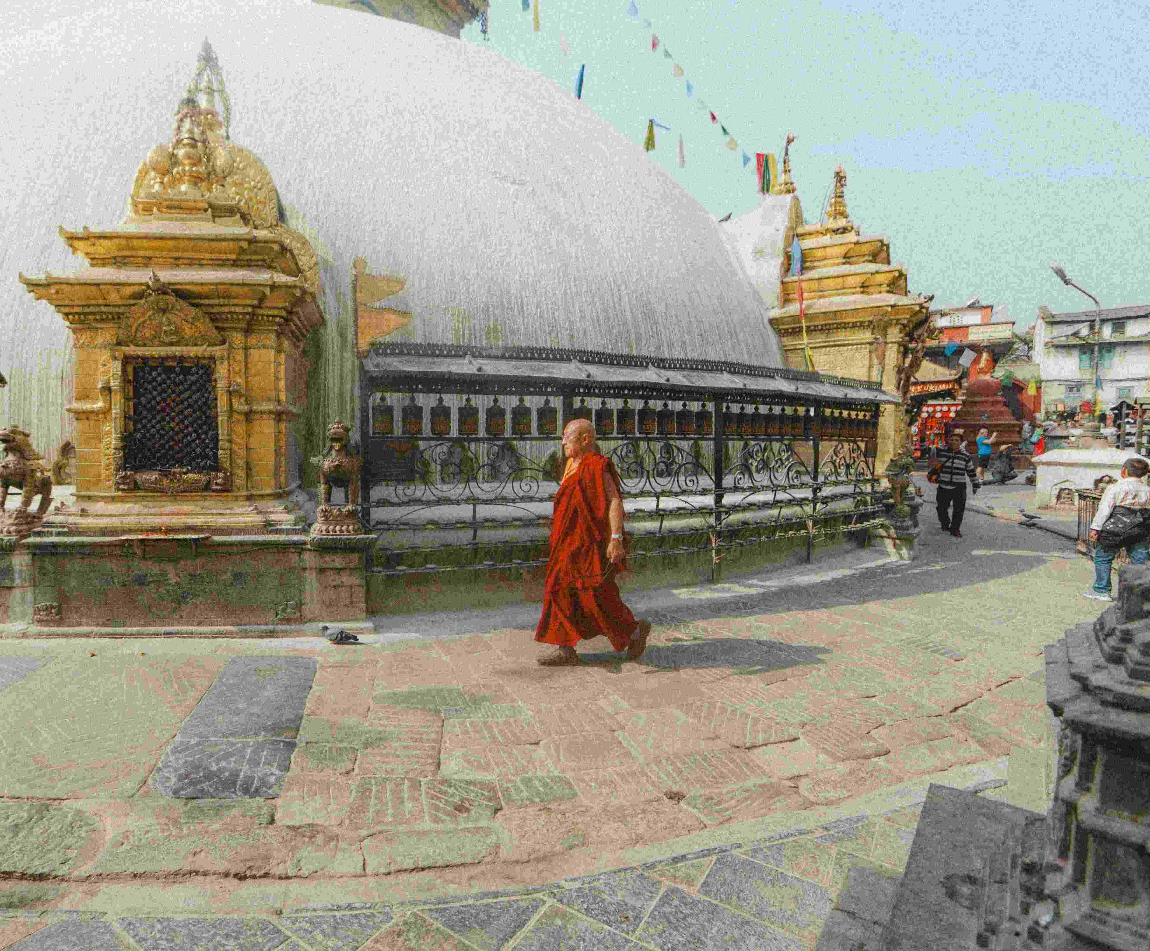 Buddhist monk in red robe walking past a large stupa with ornate railings, surrounded by temple visitors in a serene religious setting