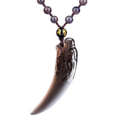 Carved black obsidian wolf fang pendant, symbolizing courage and resilience, ideal for those seeking protection.