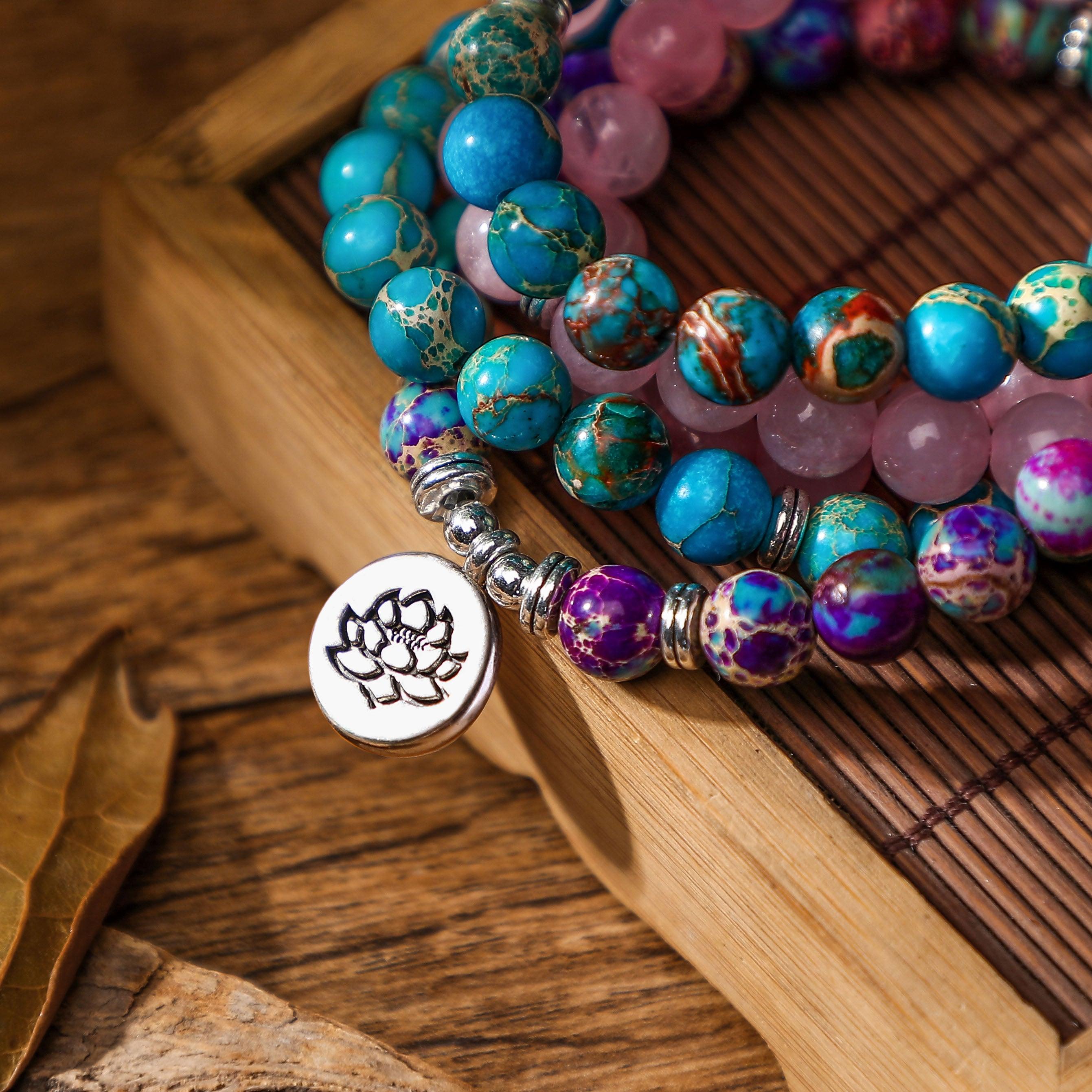 Close-up of a lotus charm mala bracelet, showcasing colorful turquoise, purple agate, and rose quartz beads arranged for spiritual harmony and style.
