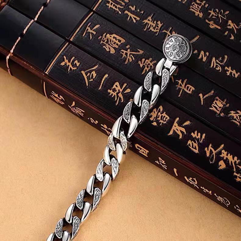 Close-up of religious symbols engraved on the bracelet, representing spirituality and protection.