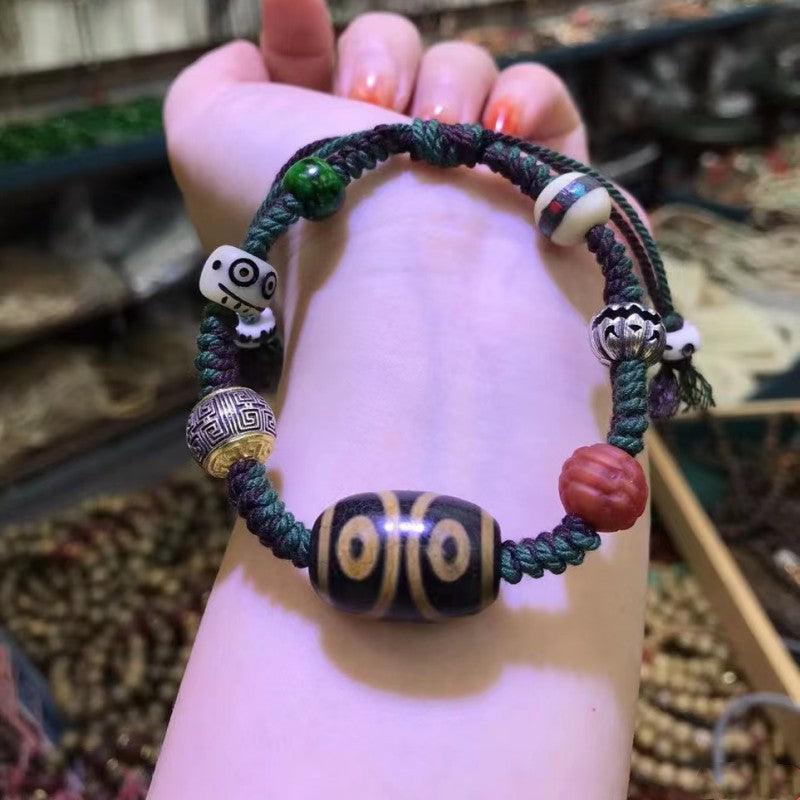 Close-up of the central Dzi bead, showcasing its double-eyed pattern believed to attract good fortune and protection.