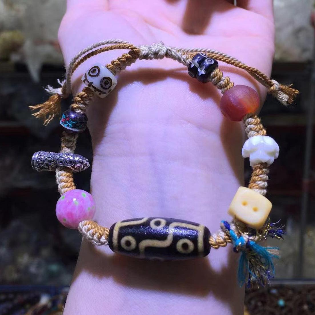 Close-up of the central Tibetan Dzi bead with mystical patterns, believed to bring good fortune.