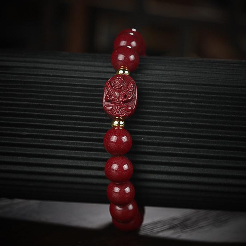 Close-up of the cinnabar bracelet’s Buddha bead, showcasing intricate engravings and vibrant red color.