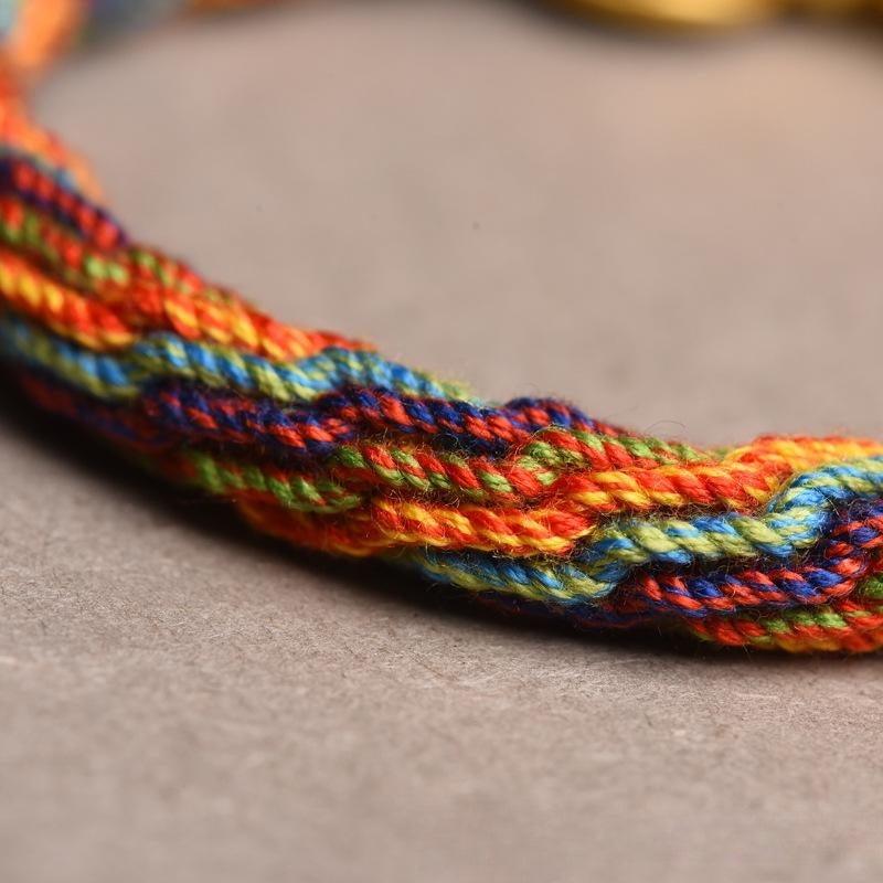 Close-up of the vibrant woven threads on Tibetan-style bracelet, showcasing intricate craftsmanship and cultural richness.