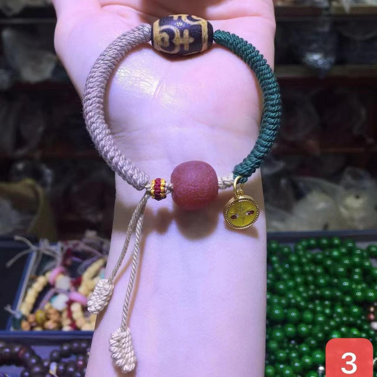 Close-up view of the bracelet’s braided design and charms, symbolizing peace, luck, and spiritual guidance.