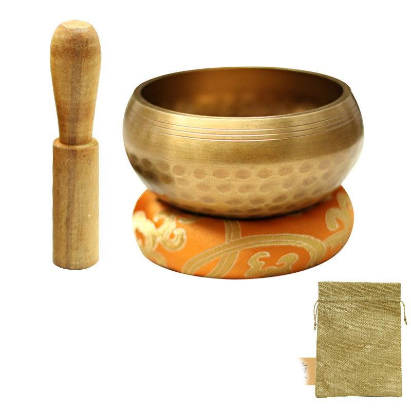 Complete Tibetan singing bowl set including a hammered brass bowl, wooden mallet, decorative cushion, and storage pouch, ideal for meditation and mindfulness.