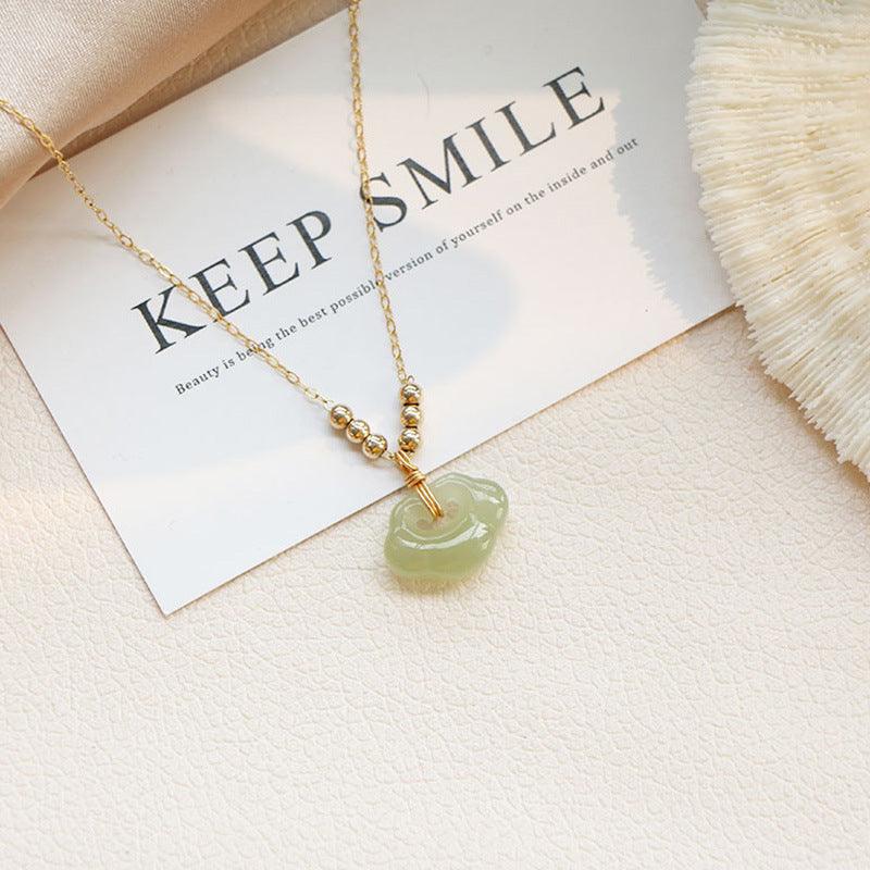 Delicate gold chain with a smooth jade pendant, showcasing intricate craftsmanship and the timeless elegance of jade jewelry.