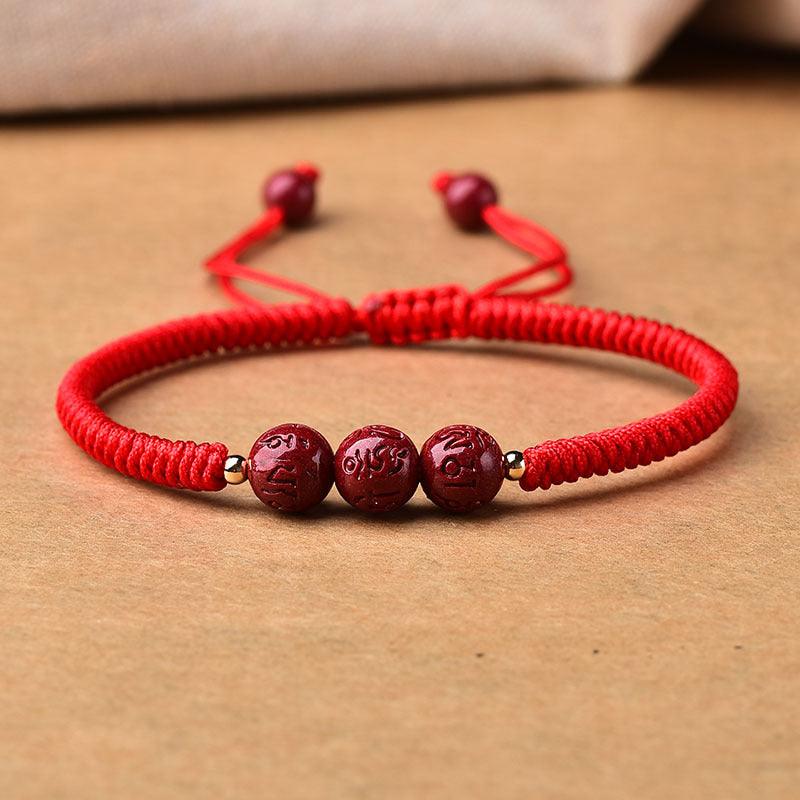 Detailed shot of the engraved cinnabar beads, highlighting the smooth finish and craftsmanship.