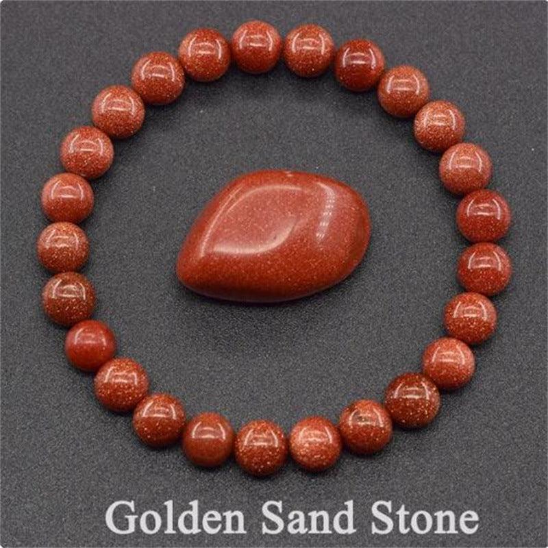 Detailed view of the Golden Sand Stone bracelet, capturing the golden sparkles on a warm orange-red background, symbolizing confidence and motivation.