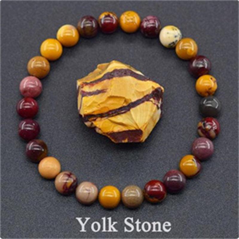 Detailed view of the Yolk Stone bracelet, showcasing the earthy maroon and yellow stones that embody strength and resilience.