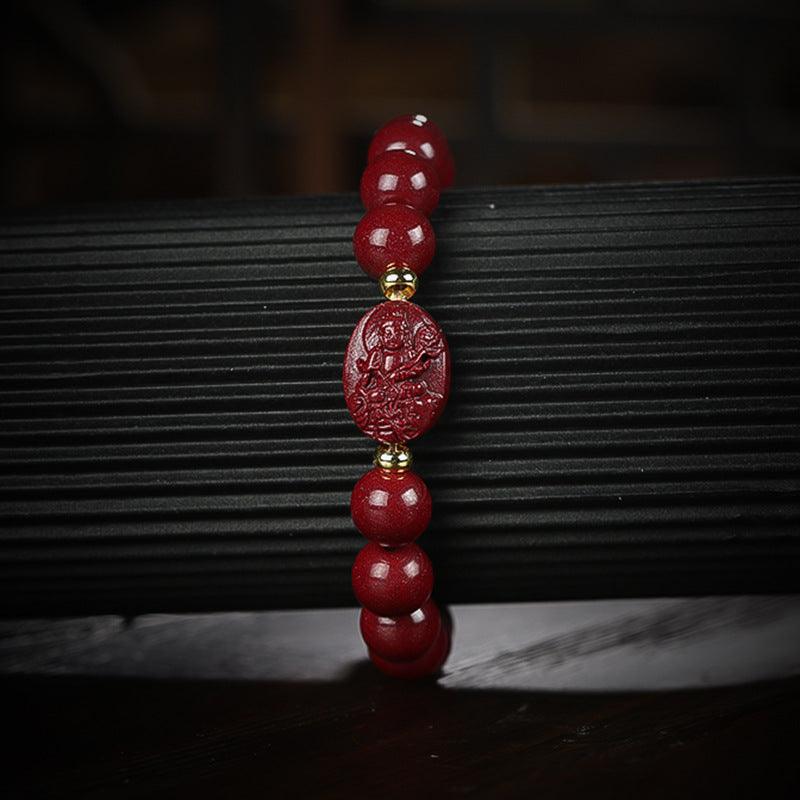 Detailed view of the cinnabar beads and Buddha carving, symbolizing protection and inner peace.