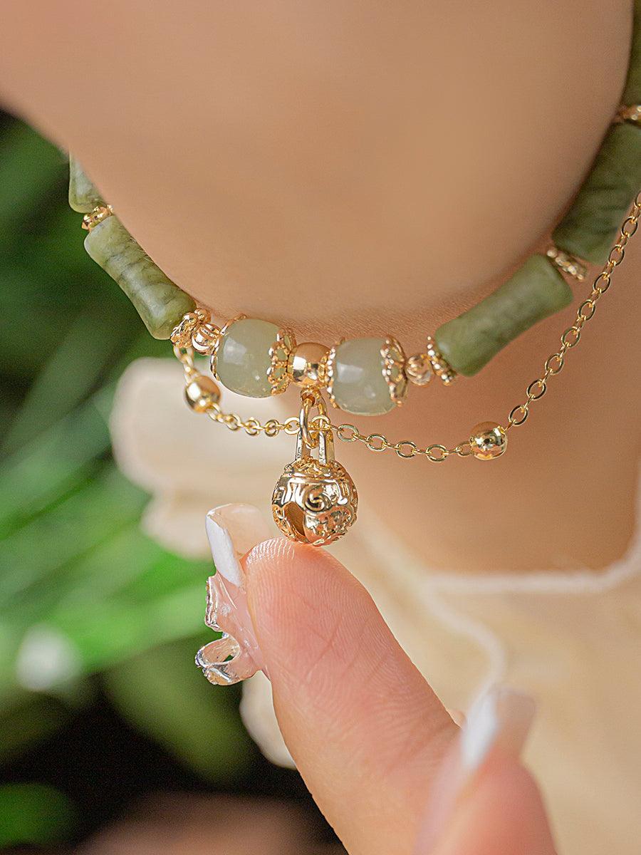 Detailed view of the jade and gold bracelet, highlighting the refined finish of each bead.