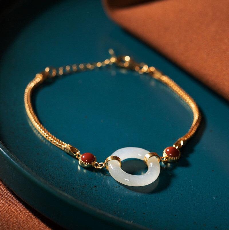 Elegant Hetian jade bracelet with red accents, symbolizing peace and prosperity.
