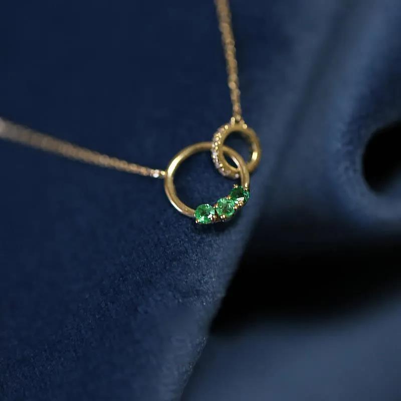Elegant Swarovski crystal necklace with interlocking rings, adorned with vibrant green crystals, symbolizing unity and grace.