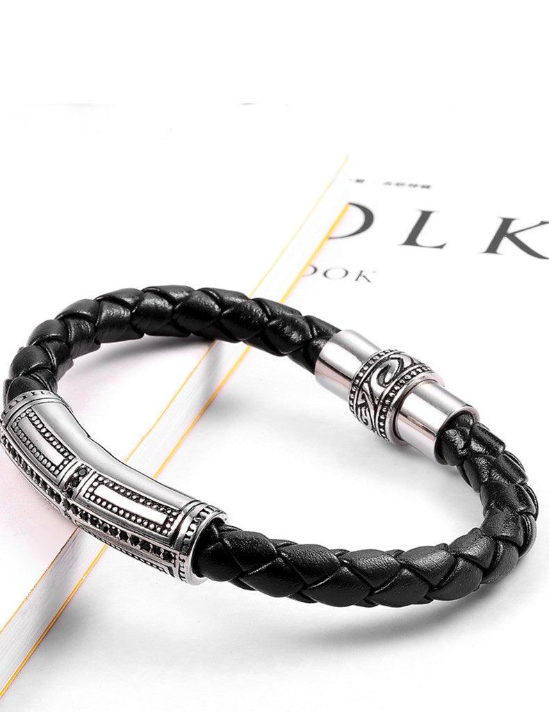 Elegant black leather bracelet with a metallic tube, great for a refined and stylish accessory.