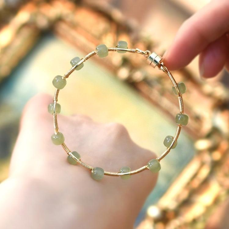 Elegant bracelet featuring translucent green stones on a refined gold band.