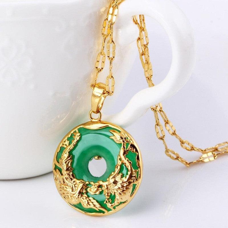 Elegant green circular pendant with gold dragon design, displayed against a white ceramic background, showcasing traditional Chinese-inspired craftsmanship.