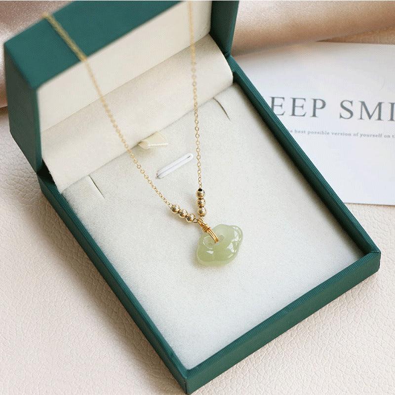 Elegant jade pendant necklace with gold chain, beautifully presented in a green gift box, symbolizing peace, protection, and elegance.