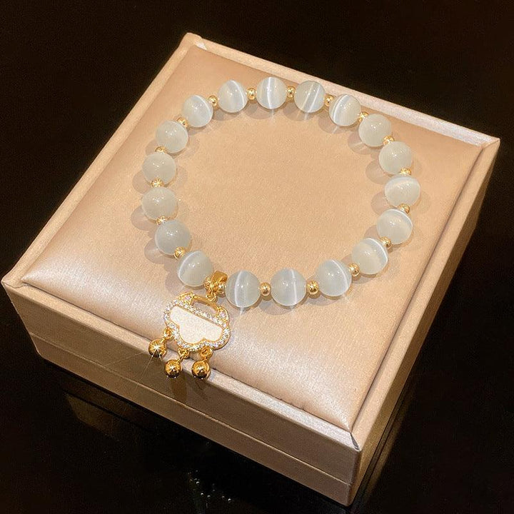 White cat-eye-style bead bracelet with gold-tone accents