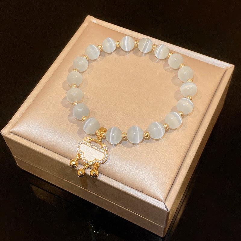 White cat-eye-style bead bracelet with gold-tone accents