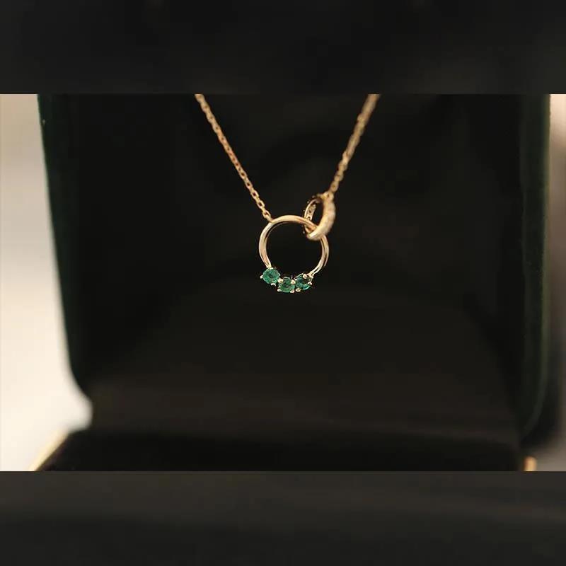 Exquisite interlinked ring necklace with Swarovski green crystals, symbolizing harmony and timeless style.