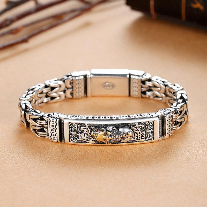 Exquisite silver bracelet with intricate dragon and Chinese characters, symbolizing strength and prosperity.