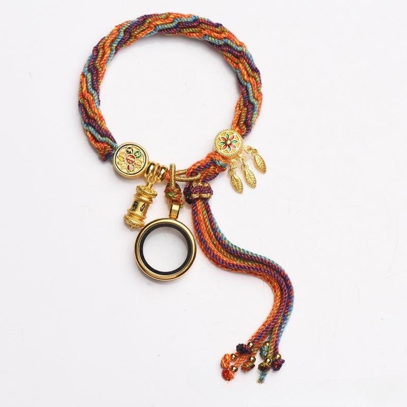 Full view of Tibetan-style multicolored woven bracelet with gold charms, symbolizing spirituality, protection, and cultural richness.