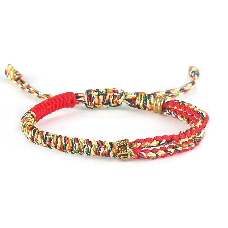 Full view of Tibetan-style red woven bracelet with multicolored cord and brass accents, symbolizing passion, vitality, and cultural depth.