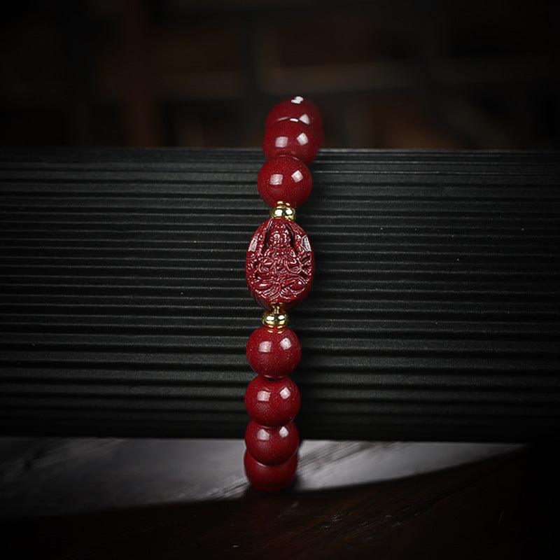 Full view of a cinnabar bracelet with a central engraved Buddha bead, symbolizing peace and protection.