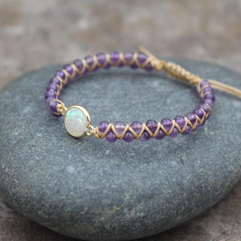 Full view of a gemstone bracelet with a central opalescent stone, surrounded by soft purple natural beads.