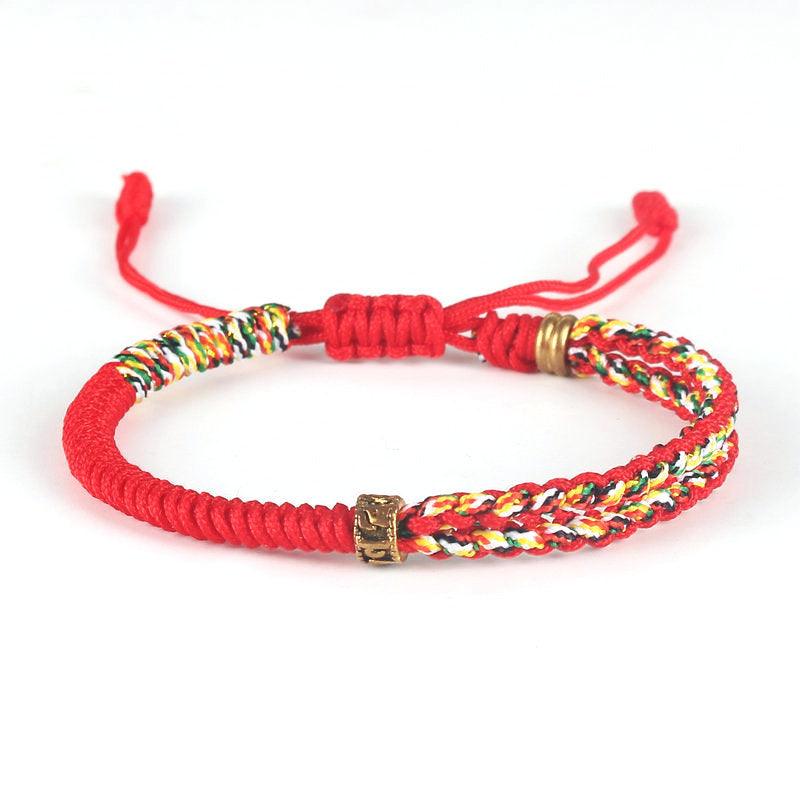 Full view of vibrant red woven bracelet with multicolored cord and brass accents, symbolizing energy, protection, and cultural vibrance.