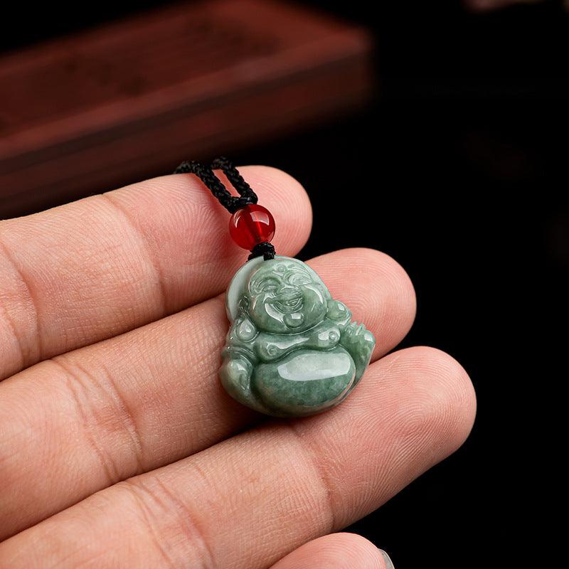 Green jade Buddha pendant, a symbol of peace, with a vibrant red bead accent.