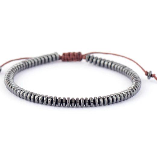 Gun black Tiger Eye bracelet with polished, disk-shaped beads, meticulously crafted to symbolize protection and resilience. Perfect for individuals seeking an accessory that blends style with symbolic meaning.