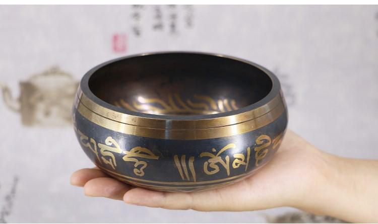 Hand-held view of the Tibetan Singing Bowl in use, creating resonant tones for meditation and mindfulness.