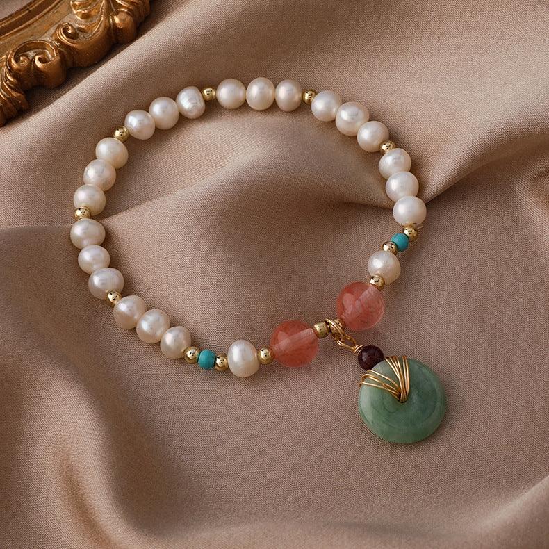 Handcrafted bracelet featuring pearls known for calming energy, with red and green gemstones believed to enhance vitality and inner peace.