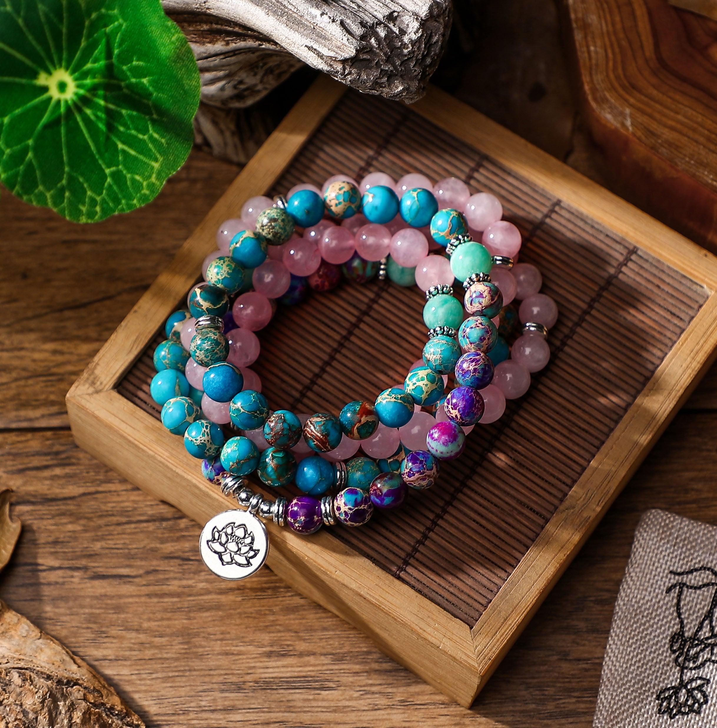 Handcrafted lotus charm mala with 108 beads, combining vibrant turquoise, rose quartz, and purple agate for spiritual grounding and harmony.