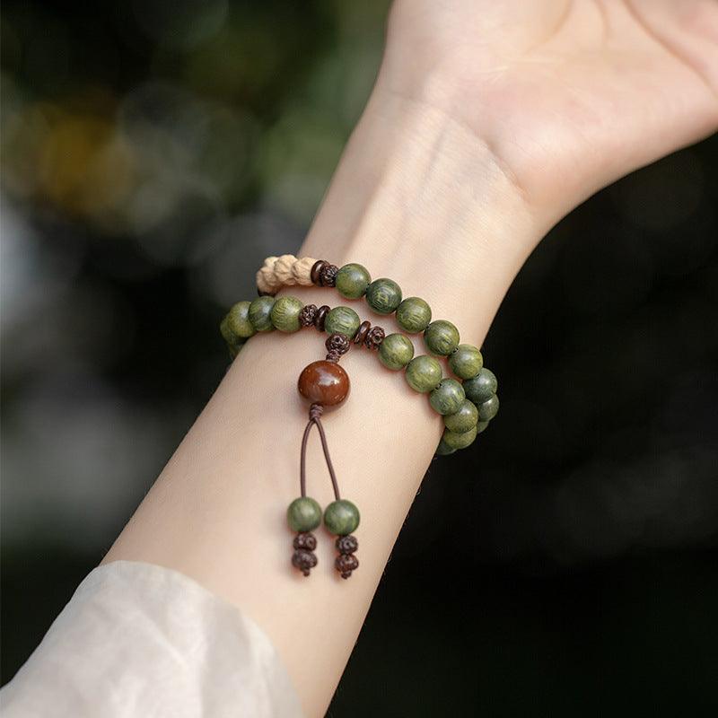 Handcrafted mala beads bracelet in rich green wood, perfect for peaceful meditation.
