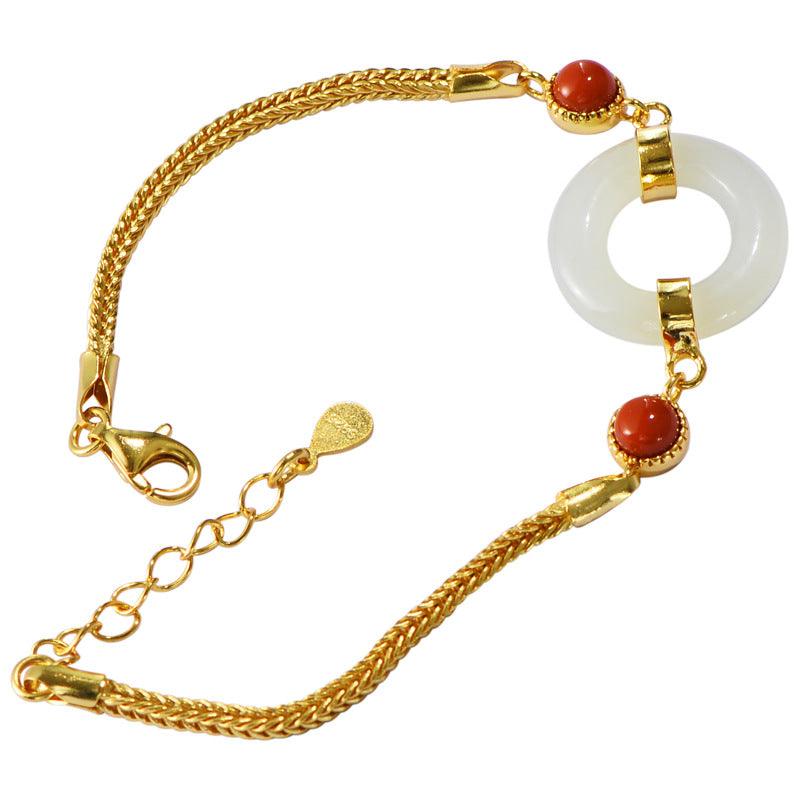 Hetian jade bracelet with red bead accents, a symbol of peace and prosperity.