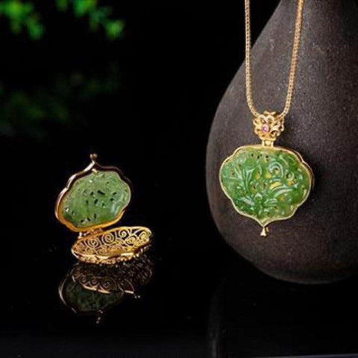 Green jade-style pendant with ornate floral metal frame