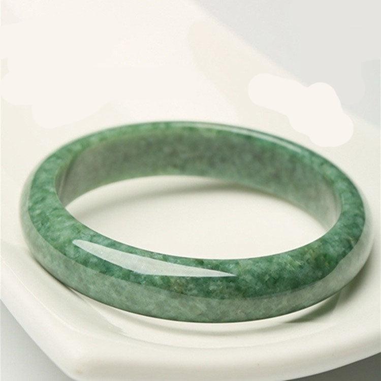 Jade bangle with subtle marbling, each piece unique due to the natural variations in jade, adding to its charm and authenticity.
