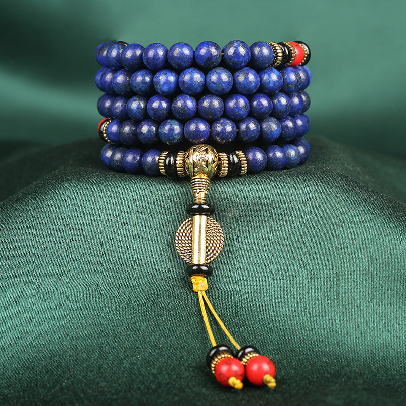 Lapis Lazuli mala with 108 beads and red accents, symbolizing tranquility and spiritual wisdom.